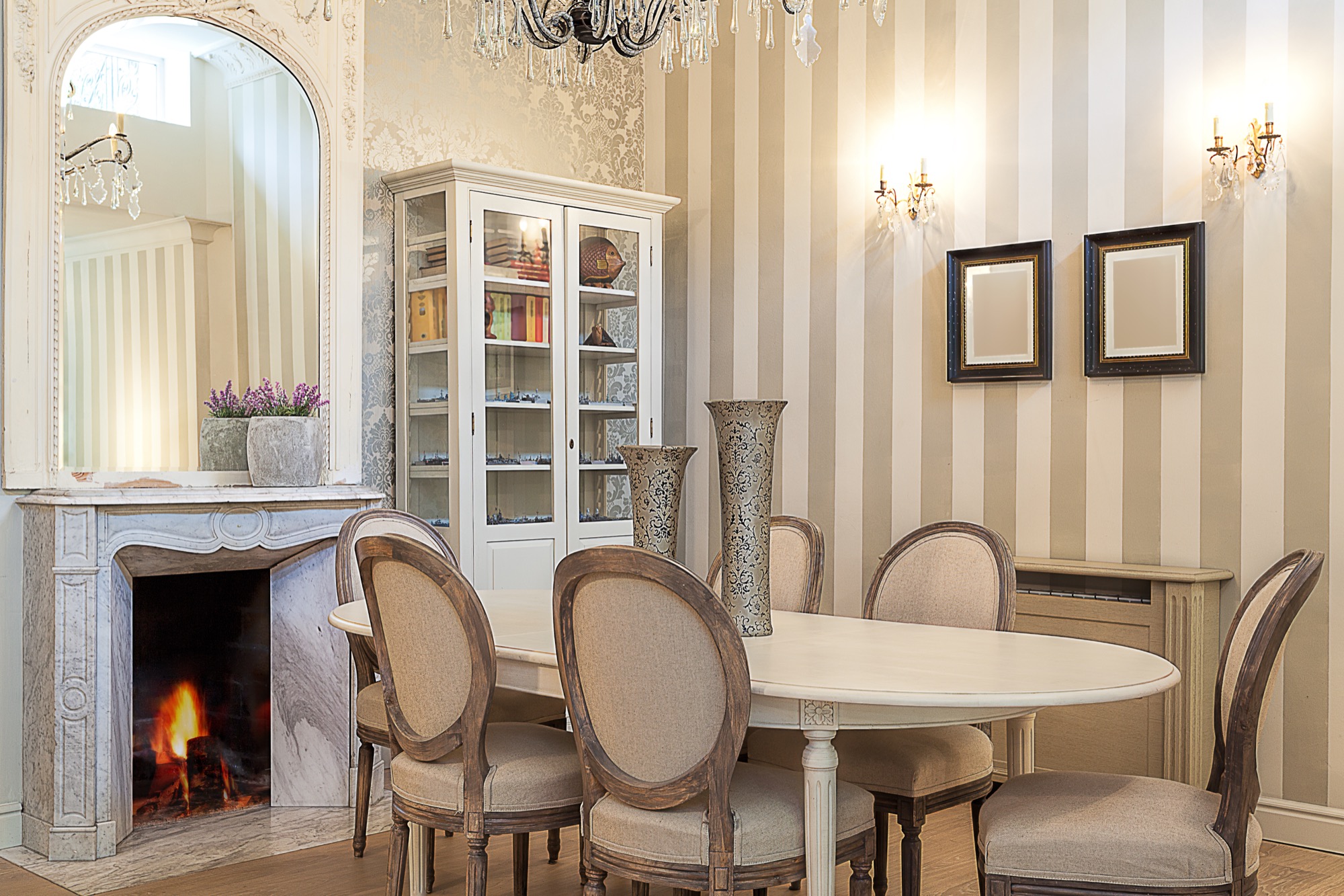 Elegant private dining room with a fireplace and chandelier, set for a small dinner party
